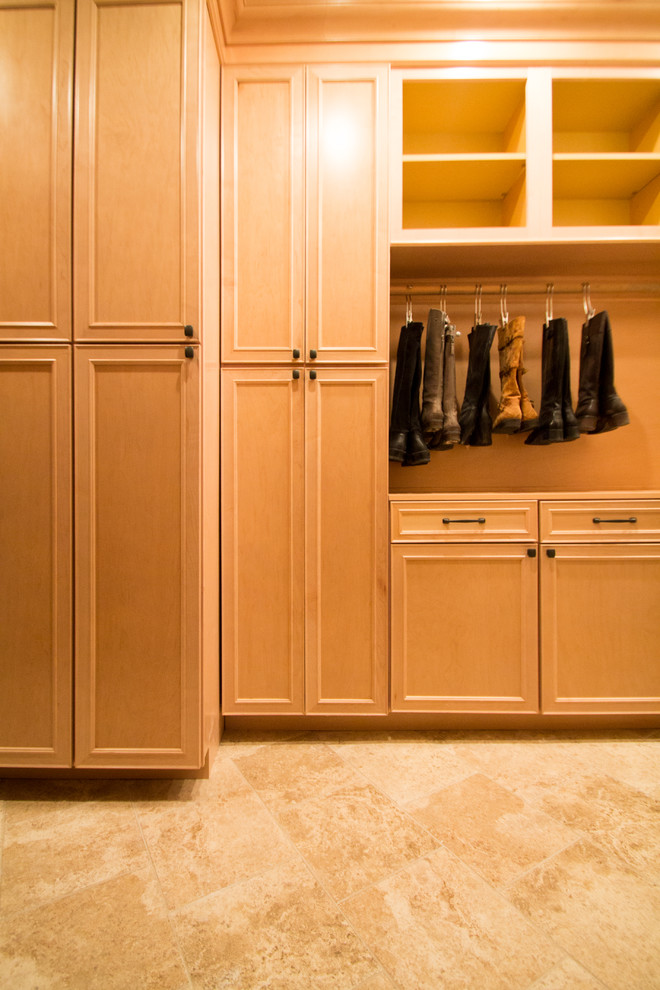 Photo of a large traditional gender-neutral walk-in wardrobe in Denver with raised-panel cabinets, light wood cabinets, travertine floors and beige floor.