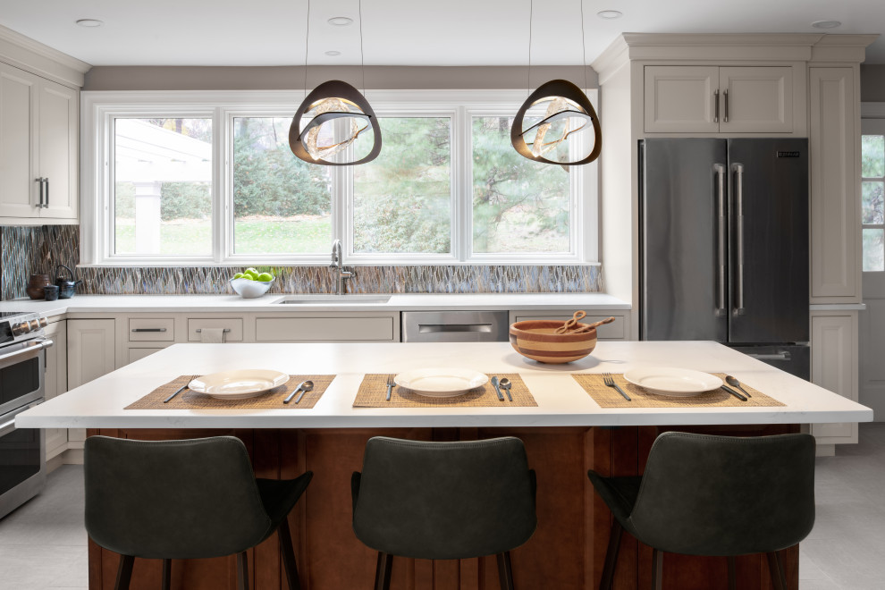 Eat-in kitchen - large transitional porcelain tile eat-in kitchen idea in Boston with a single-bowl sink, quartz countertops, multicolored backsplash, glass tile backsplash, stainless steel appliances, an island and white countertops
