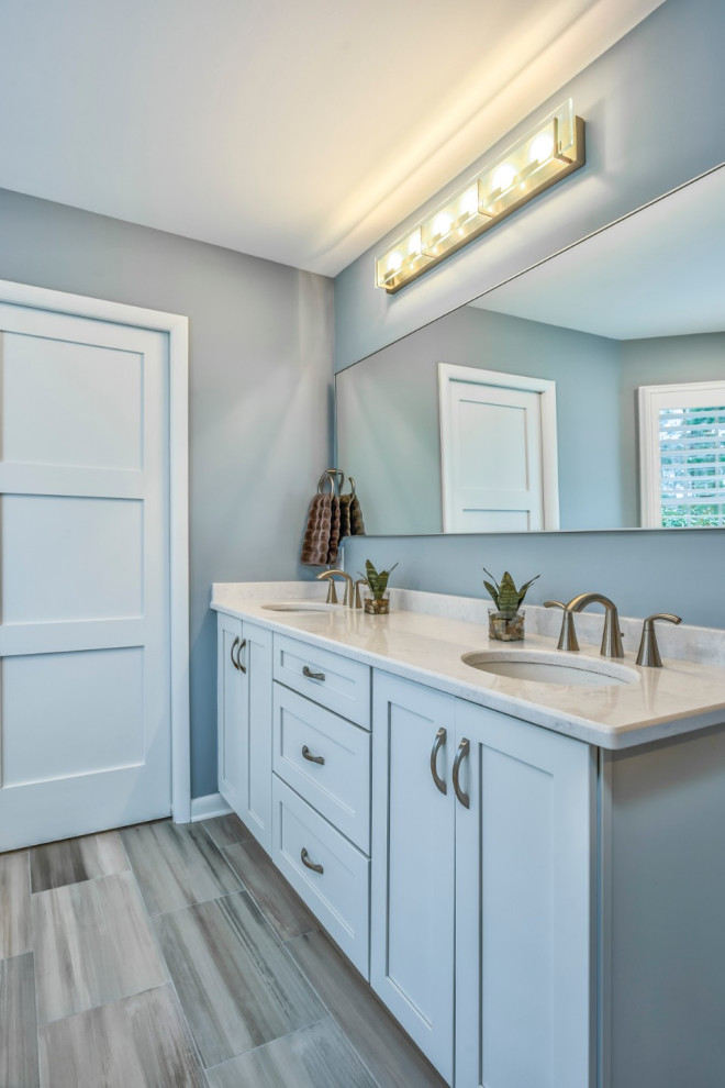 Immagine di una stanza da bagno padronale stile marinaro con ante in stile shaker, ante bianche, pavimento con piastrelle in ceramica, lavabo sottopiano, top in granito, pavimento grigio, top bianco e due lavabi