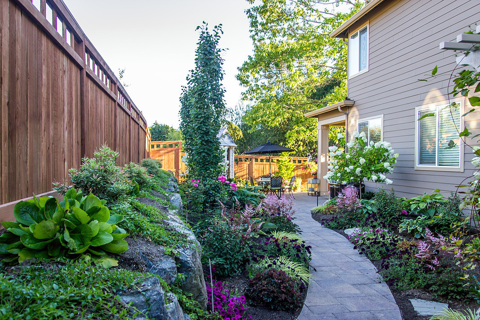 Large traditional backyard partial sun garden in Seattle with a garden path and concrete pavers for summer.