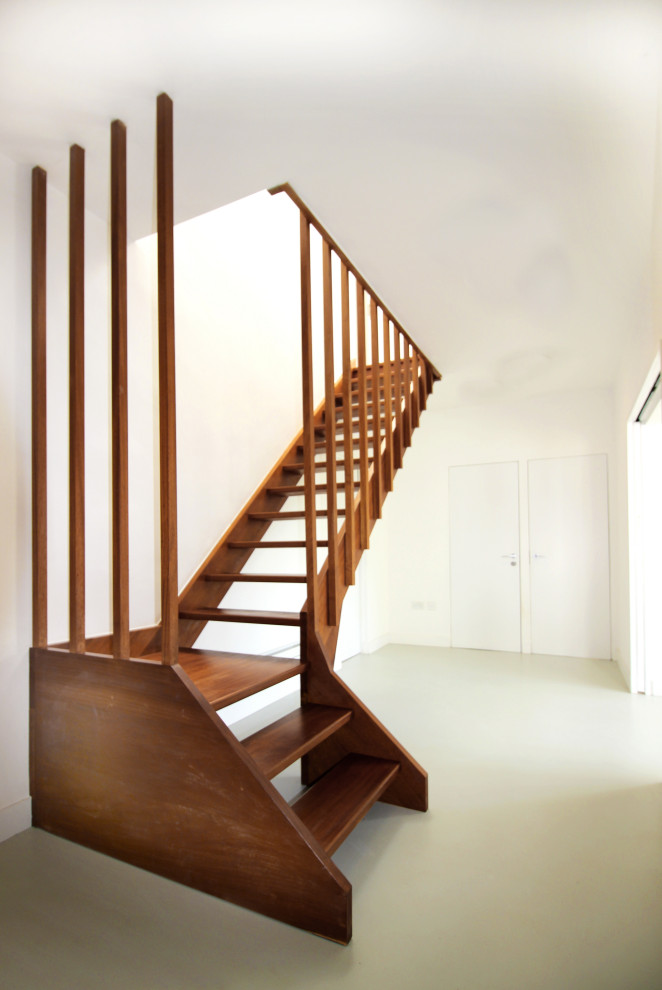 Inspiration for a mid-sized modern wooden l-shaped wood railing staircase remodel in London with wooden risers