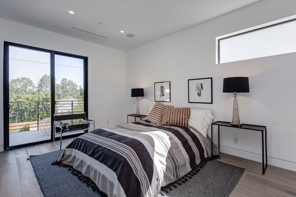 Inspiration for a contemporary bedroom in Los Angeles with white walls, light hardwood floors and grey floor.