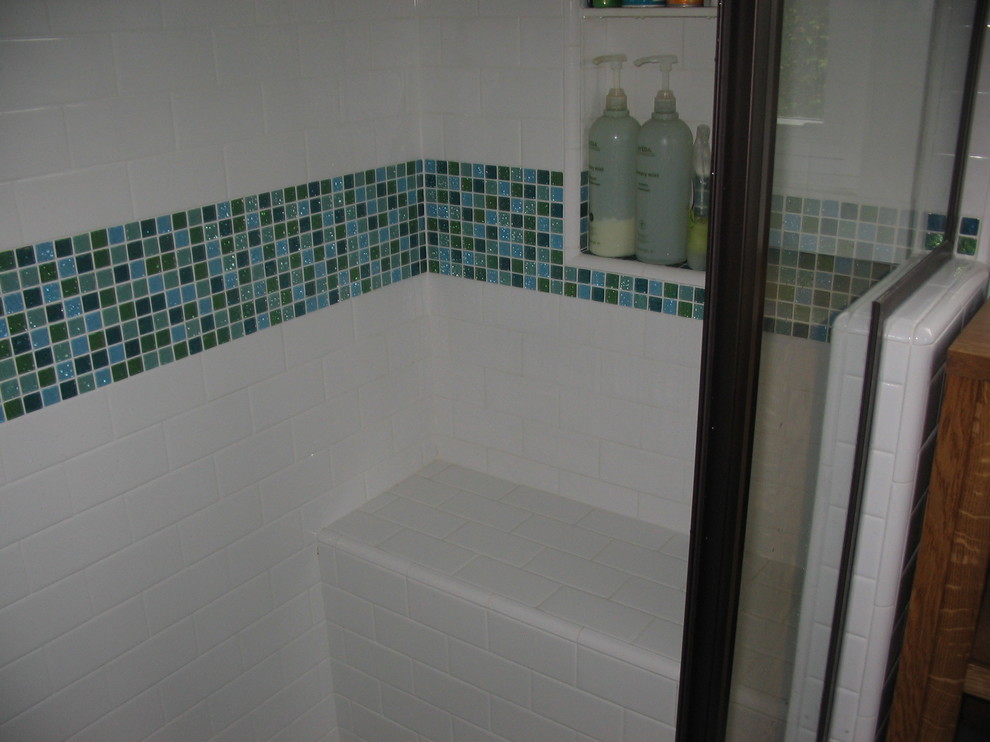 Design ideas for a mid-sized arts and crafts 3/4 bathroom in San Diego with flat-panel cabinets, medium wood cabinets, an alcove shower, a two-piece toilet, blue tile, mosaic tile, white walls, ceramic floors, an integrated sink, glass benchtops, brown floor and a hinged shower door.