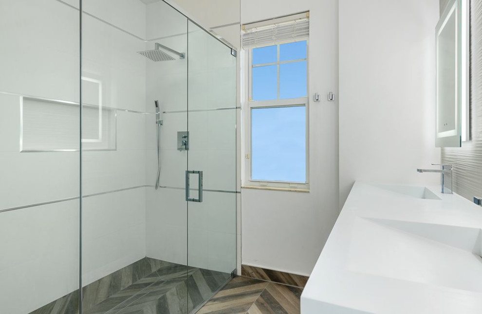 Example of a mid-sized minimalist white tile and porcelain tile porcelain tile, brown floor and single-sink walk-in shower design in Miami with glass-front cabinets, white cabinets, a one-piece toilet, white walls, an integrated sink, quartz countertops, a hinged shower door, white countertops, a niche and a floating vanity
