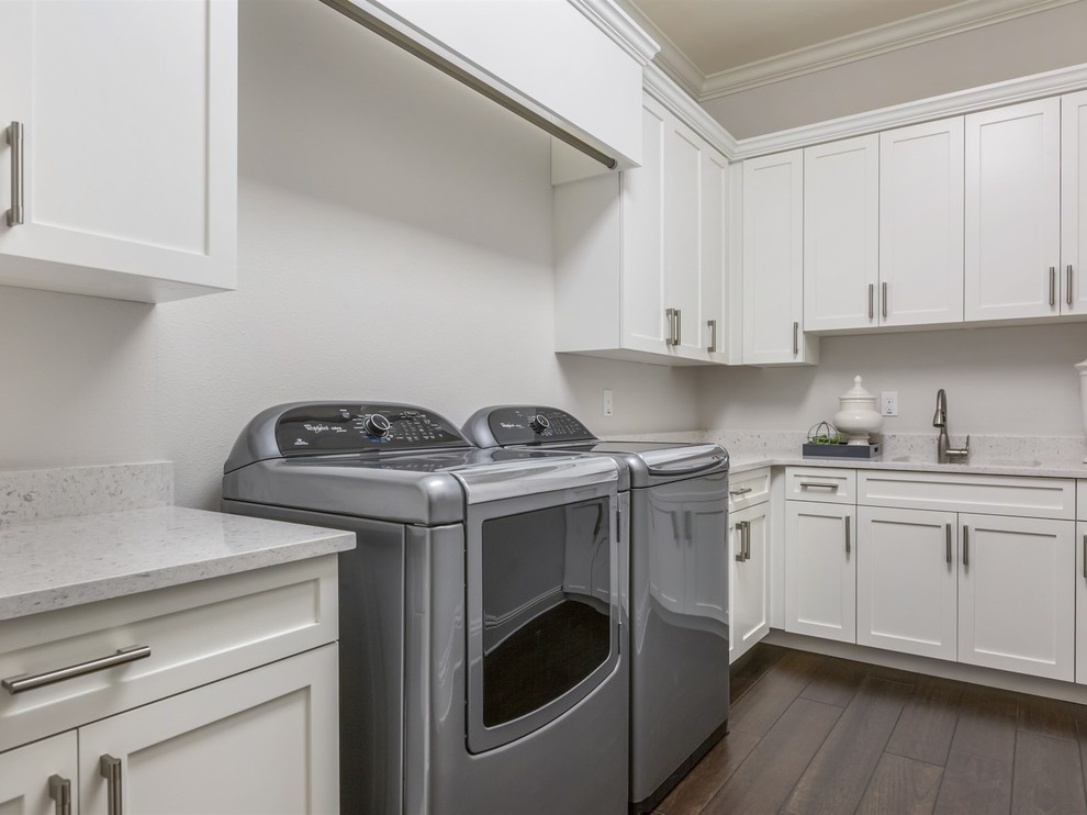 Design ideas for a large transitional l-shaped dedicated laundry room in Orlando with shaker cabinets, white cabinets, an undermount sink, quartz benchtops, beige walls, dark hardwood floors and a side-by-side washer and dryer.