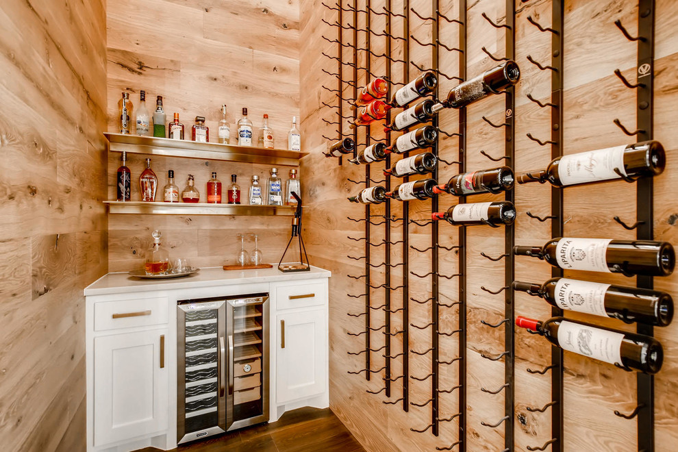 Photo of a small contemporary wine cellar in Austin with dark hardwood floors, storage racks and brown floor.