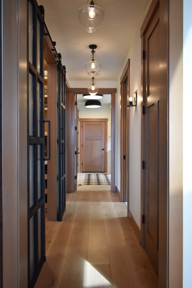 This is an example of an expansive midcentury hallway in Seattle with white walls, medium hardwood floors and grey floor.