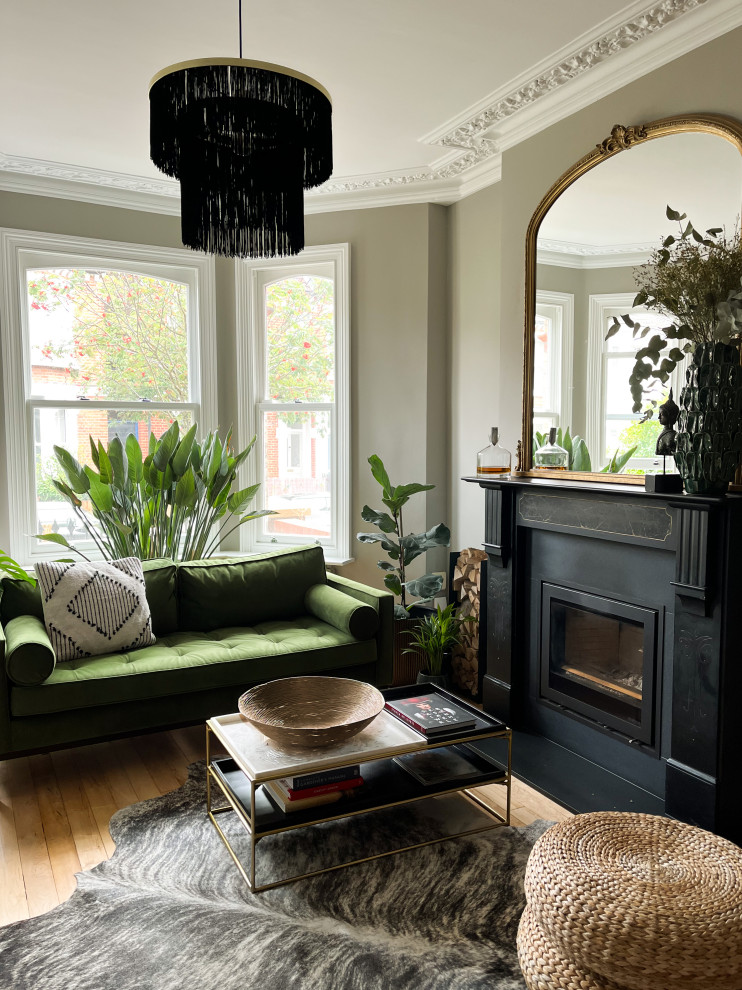 Geräumiges, Offenes Klassisches Wohnzimmer mit grüner Wandfarbe, hellem Holzboden, Kaminumrandung aus Stein und Multimediawand in Hertfordshire
