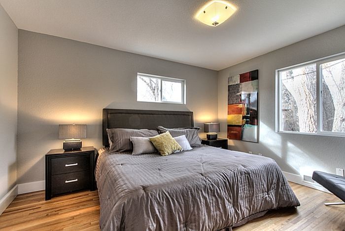 Example of a mid-sized transitional guest light wood floor bedroom design with gray walls