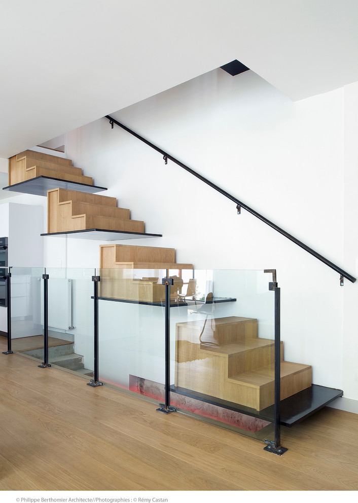 Design ideas for a large contemporary wood floating staircase in Paris with wood risers.