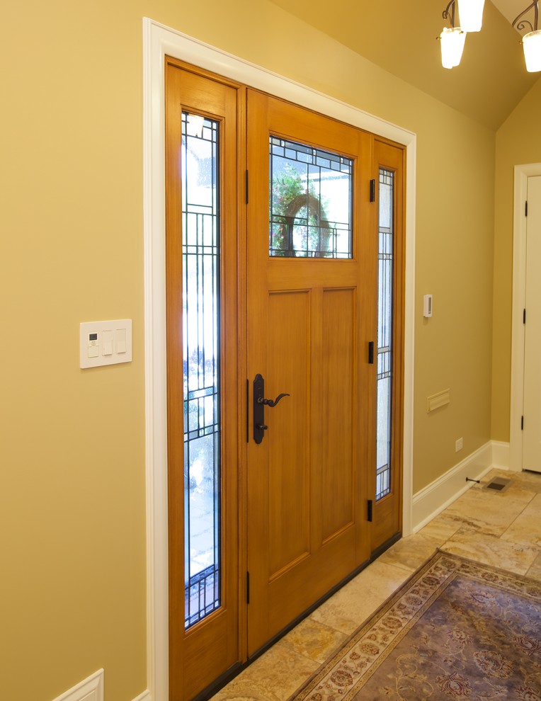 This is an example of a small traditional foyer in Chicago with yellow walls and porcelain floors.