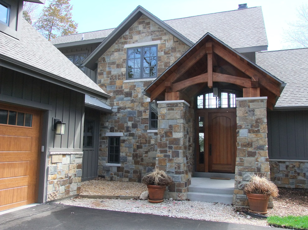Inspiration for a mid-sized traditional two-storey grey exterior in Milwaukee with stone veneer and a hip roof.
