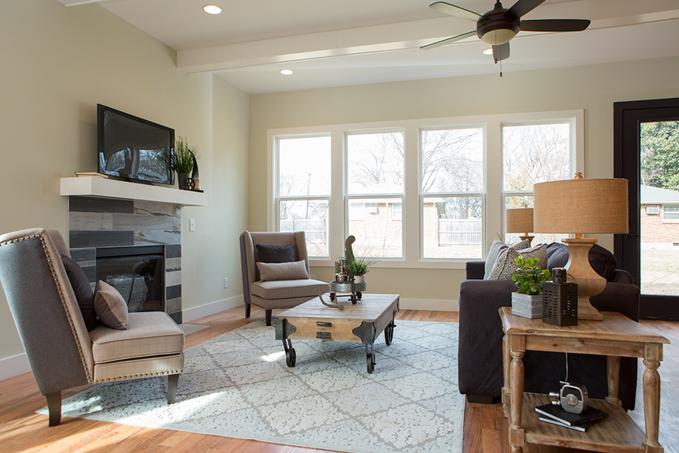 Photo of a mid-sized industrial open concept living room in Nashville with medium hardwood floors, a standard fireplace and a tile fireplace surround.