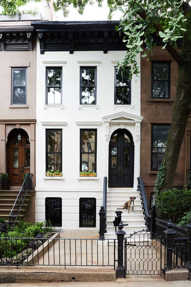 This is an example of a transitional three-storey white townhouse exterior in New York.
