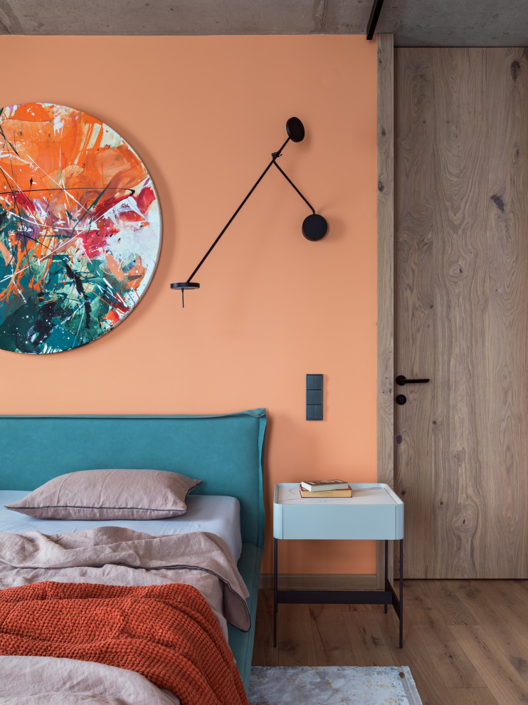 他の地域にある中くらいなインダストリアルスタイルのおしゃれな主寝室 (オレンジの壁、無垢フローリング、暖炉なし、茶色い床、アクセントウォール)