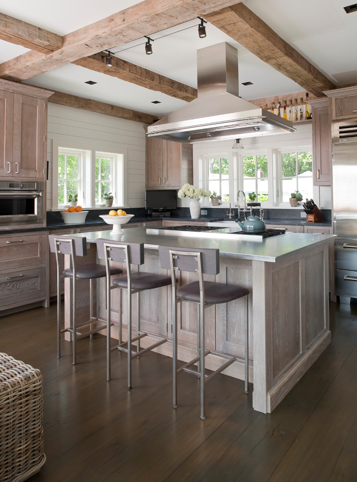 Design ideas for a large beach style l-shaped kitchen in Bridgeport with stainless steel appliances, stainless steel benchtops, recessed-panel cabinets, distressed cabinets, grey splashback, dark hardwood floors and with island.