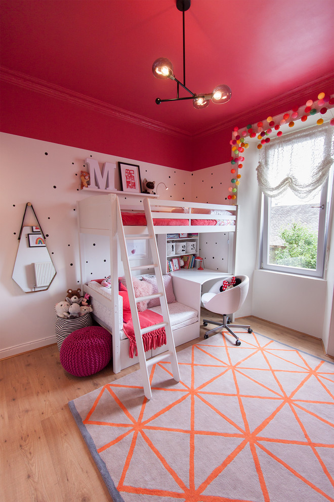 This is an example of a mid-sized transitional kids' bedroom for kids 4-10 years old and girls in Edinburgh with multi-coloured walls and light hardwood floors.
