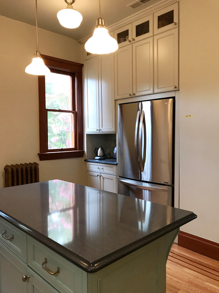 Mid-sized traditional u-shaped separate kitchen in Seattle with a farmhouse sink, shaker cabinets, grey cabinets, quartz benchtops, grey splashback, ceramic splashback, stainless steel appliances, medium hardwood floors, with island, brown floor and blue benchtop.