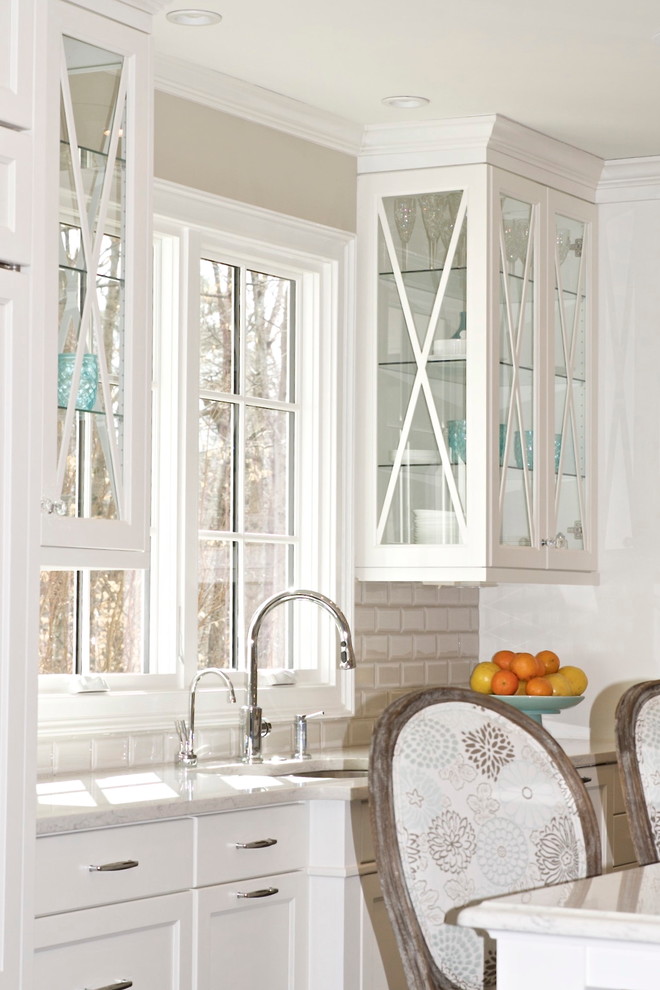 Example of a mid-sized transitional u-shaped dark wood floor eat-in kitchen design in Atlanta with an undermount sink, glass-front cabinets, white cabinets, quartz countertops, white backsplash, subway tile backsplash, paneled appliances and an island