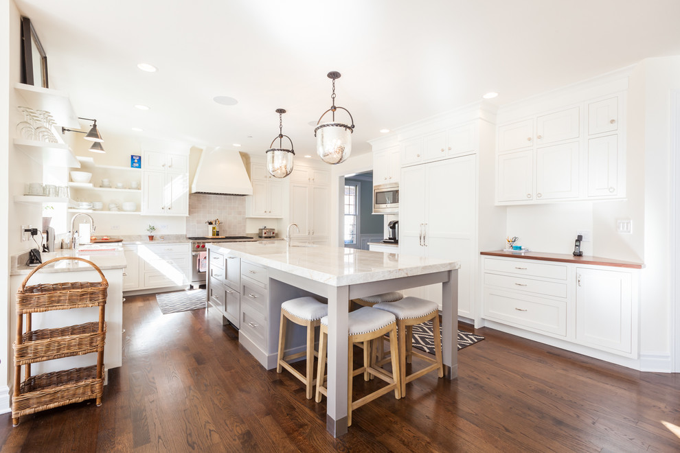 Inspiration for a large transitional u-shaped eat-in kitchen in Chicago with a farmhouse sink, shaker cabinets, white cabinets, quartzite benchtops, beige splashback, stainless steel appliances, medium hardwood floors and with island.