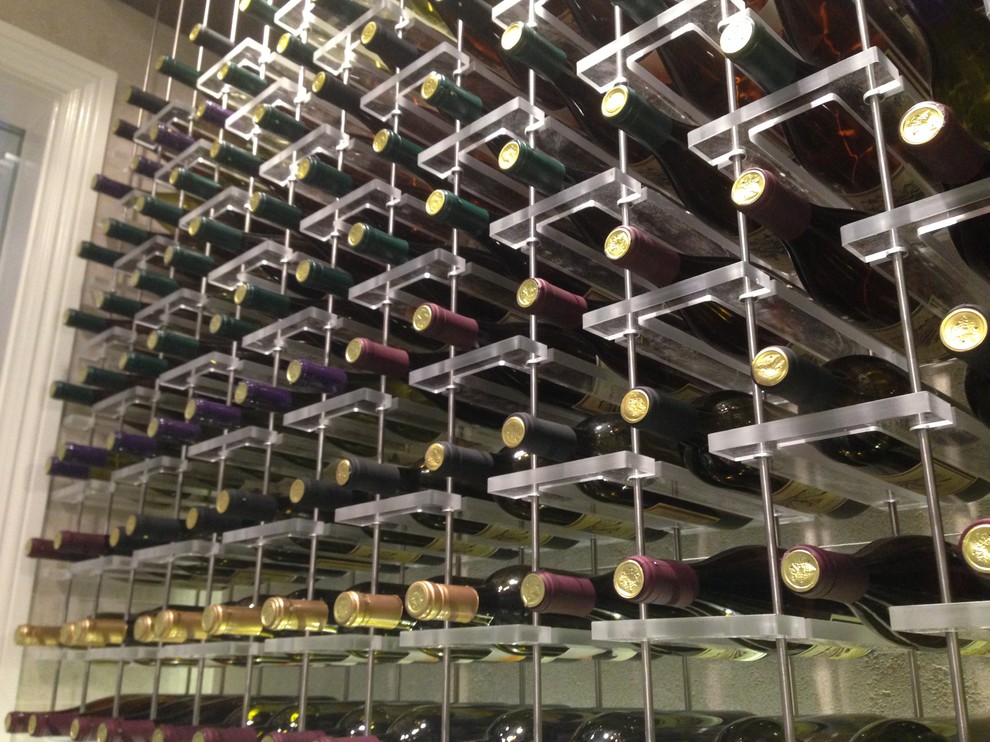 This is an example of a mid-sized industrial wine cellar in Los Angeles with ceramic floors and display racks.