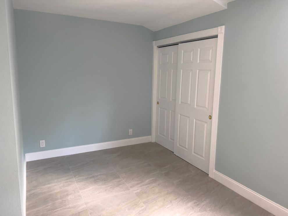 Imagen de dormitorio principal moderno de tamaño medio con paredes azules, suelo de baldosas de cerámica y suelo gris