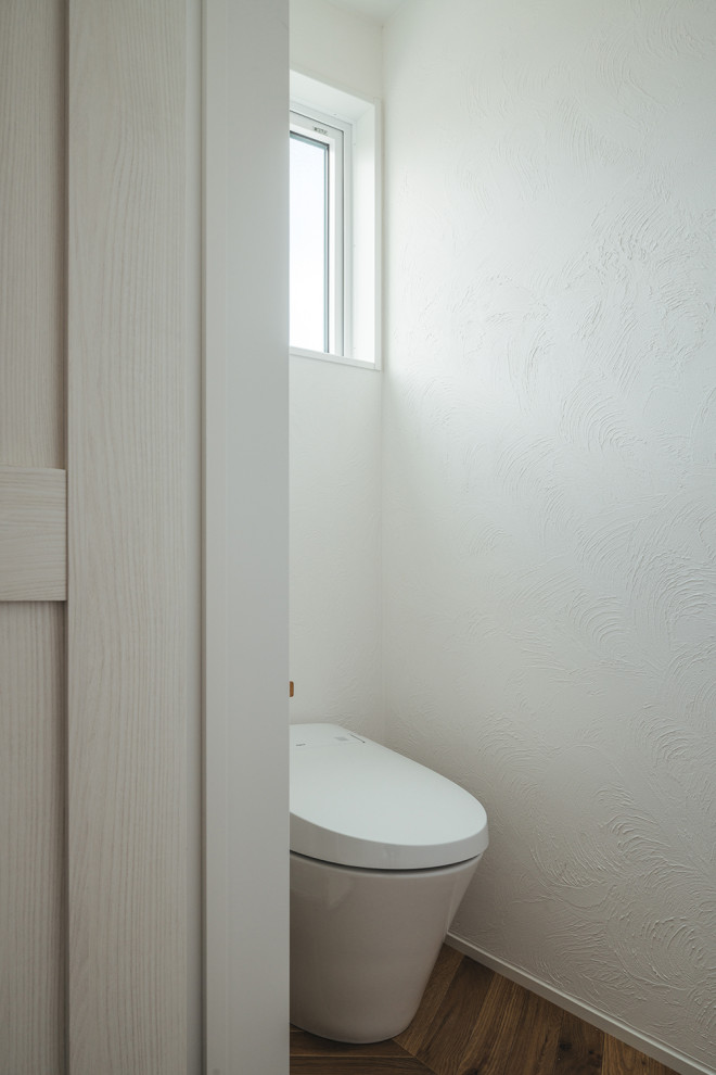 Inspiration för ett litet toalett, med en toalettstol med hel cisternkåpa, plywoodgolv och brunt golv