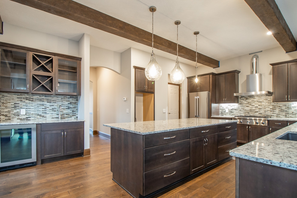 Expansive transitional eat-in kitchen in Cleveland with a drop-in sink, recessed-panel cabinets, dark wood cabinets, multi-coloured splashback, glass tile splashback, stainless steel appliances, medium hardwood floors, with island, brown floor, multi-coloured benchtop and exposed beam.