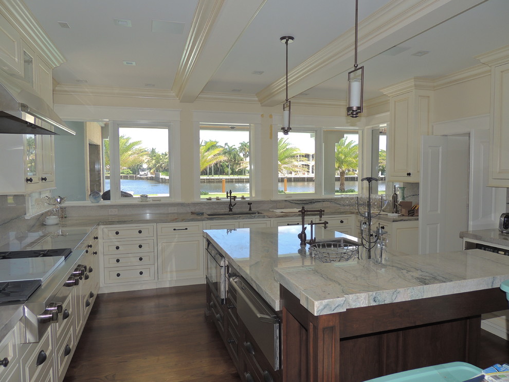 Photo of a large traditional l-shaped separate kitchen in Miami with a double-bowl sink, raised-panel cabinets, white cabinets, marble benchtops, green splashback, stainless steel appliances, dark hardwood floors and with island.