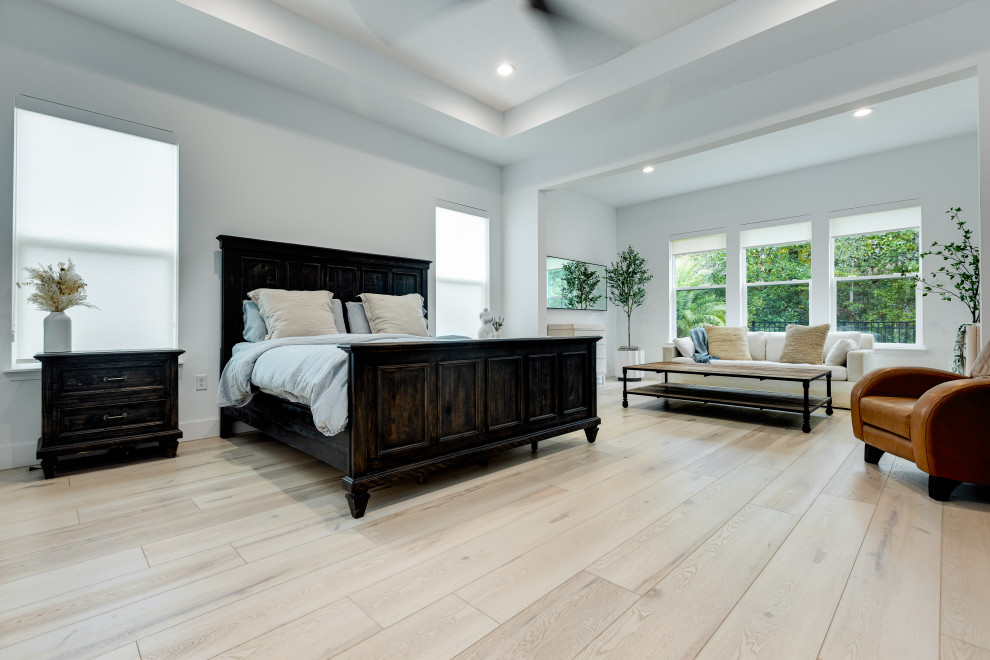 Design ideas for a mid-sized scandinavian master bedroom in Jacksonville with white walls, vinyl floors, no fireplace, beige floor and vaulted.