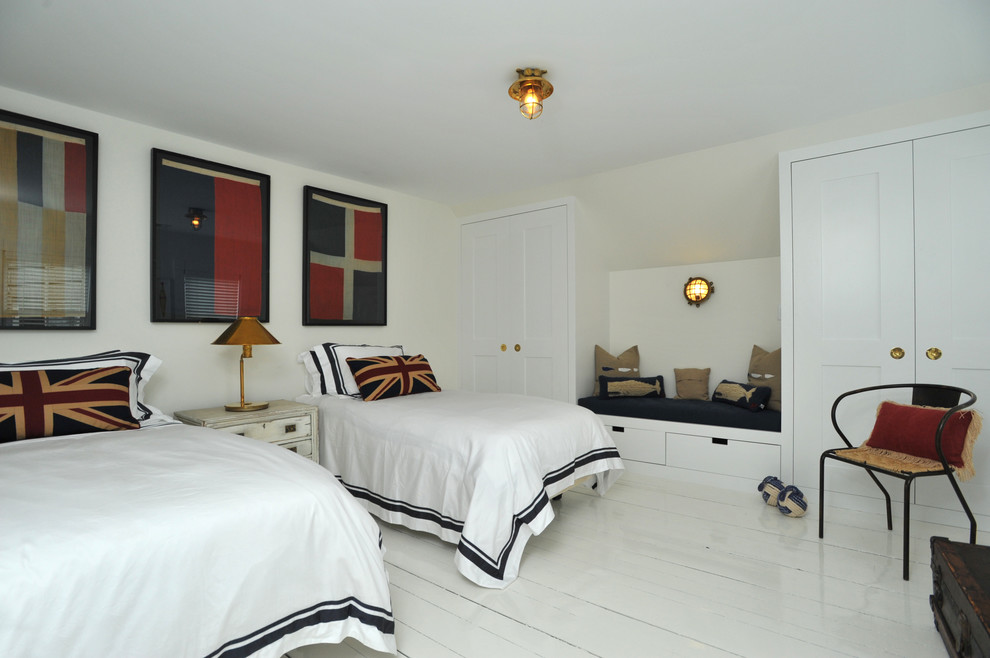 Photo of a mid-sized contemporary guest bedroom in London with white walls and painted wood floors.