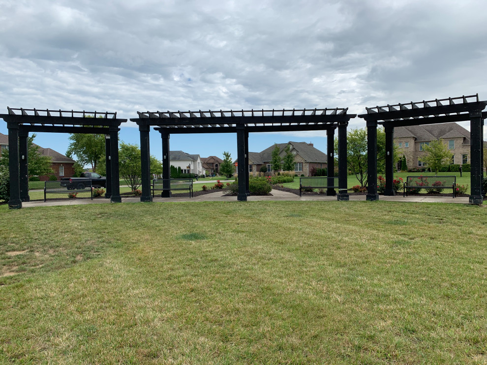 Photo of a large traditional courtyard patio in Indianapolis with concrete slabs and a pergola.