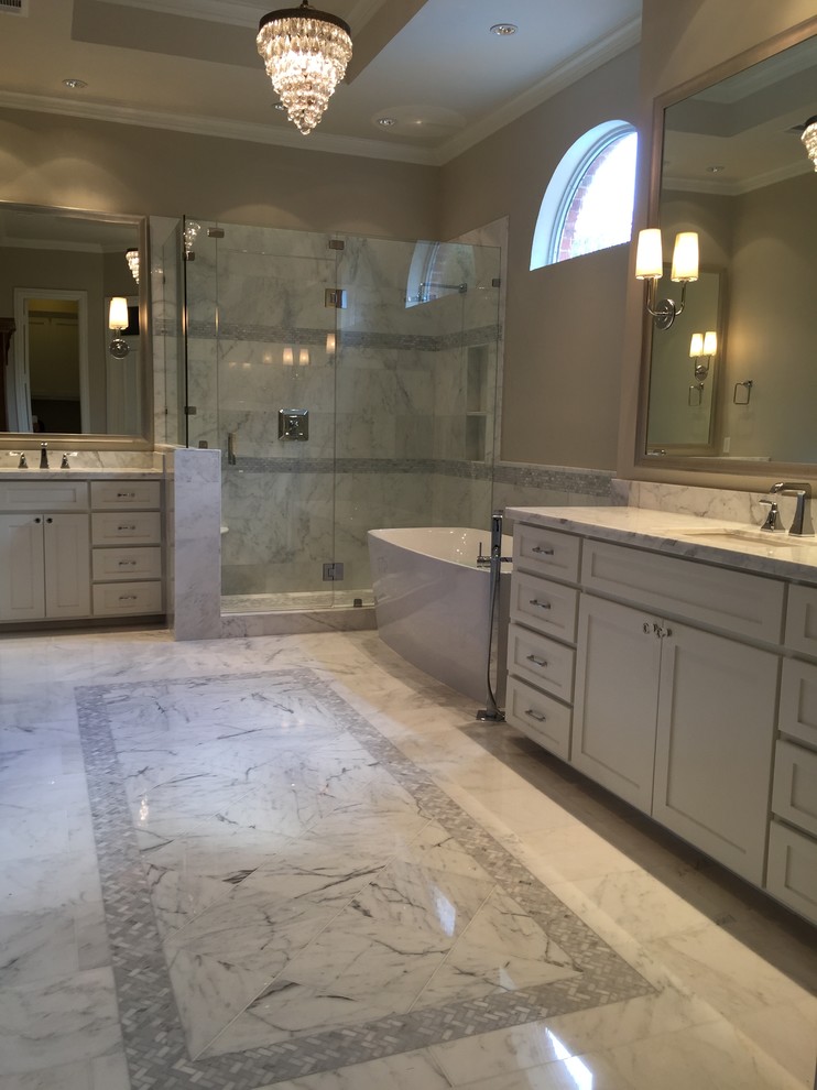 Design ideas for a large modern master bathroom in Dallas with an undermount sink, shaker cabinets, white cabinets, marble benchtops, a freestanding tub, a corner shower, a one-piece toilet, white tile, stone tile, white walls and marble floors.