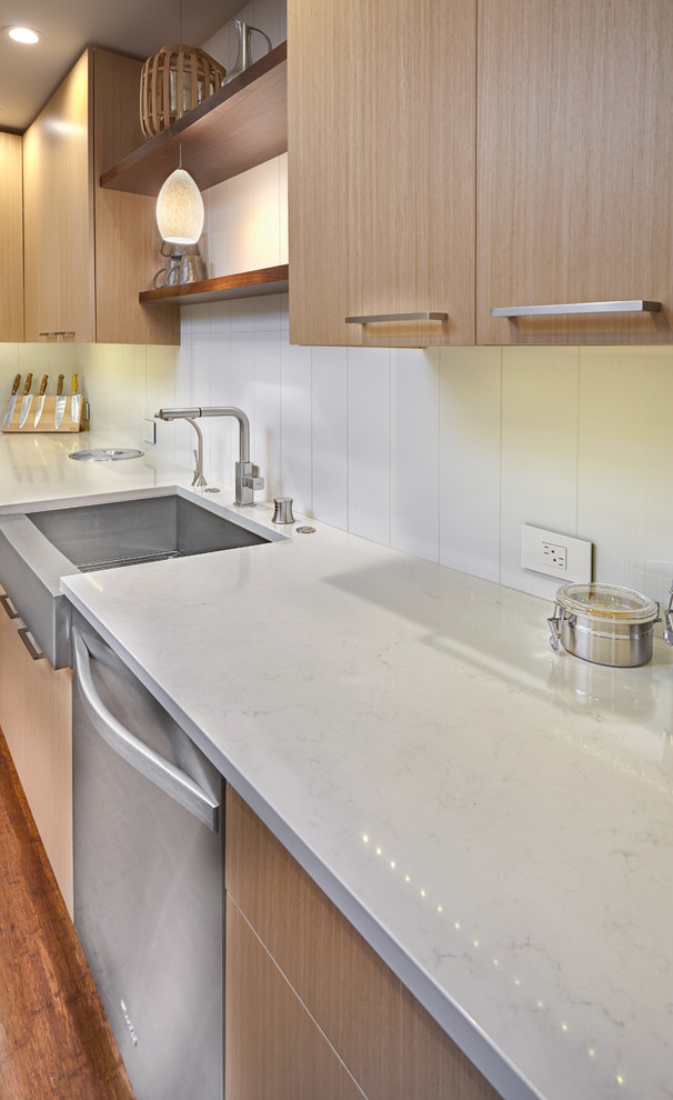 Photo of a mid-sized transitional l-shaped eat-in kitchen in Sacramento with a farmhouse sink, flat-panel cabinets, light wood cabinets, white splashback, ceramic splashback, panelled appliances, medium hardwood floors and with island.