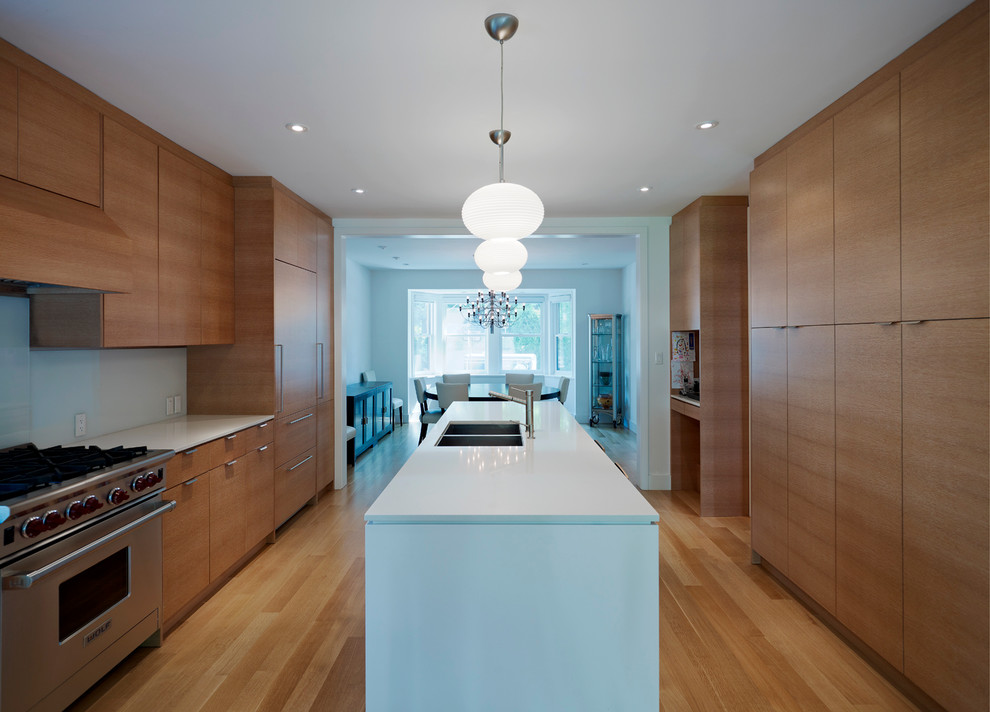 Inspiration for a large modern galley eat-in kitchen in Toronto with a double-bowl sink, flat-panel cabinets, medium wood cabinets, glass sheet splashback, panelled appliances, white splashback, light hardwood floors and with island.