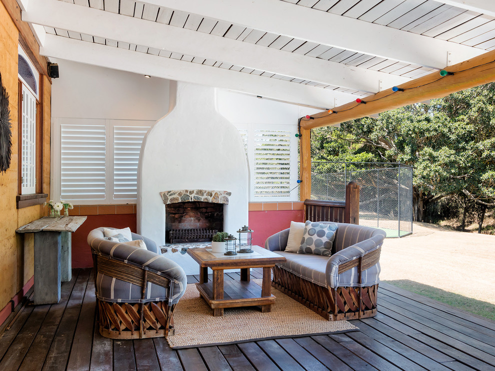 Design ideas for a mediterranean deck in Brisbane with a fire feature and a roof extension.