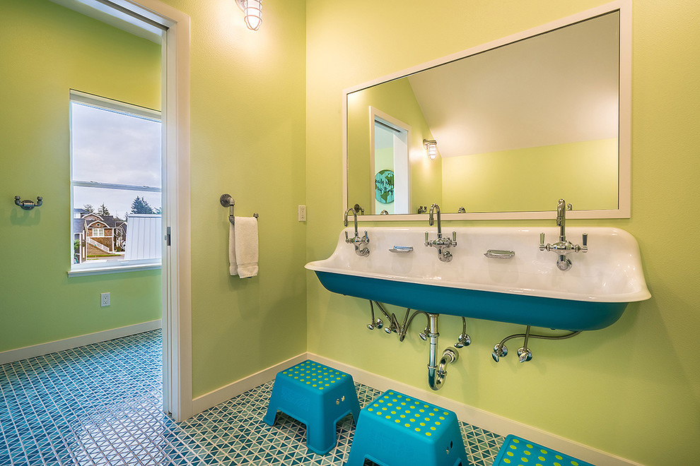 Photo of a large beach style kids bathroom in Seattle with flat-panel cabinets, brown cabinets, an alcove tub, a shower/bathtub combo, a one-piece toilet, white tile, ceramic tile, yellow walls, a wall-mount sink, engineered quartz benchtops, blue floor, a shower curtain, grey benchtops and ceramic floors.