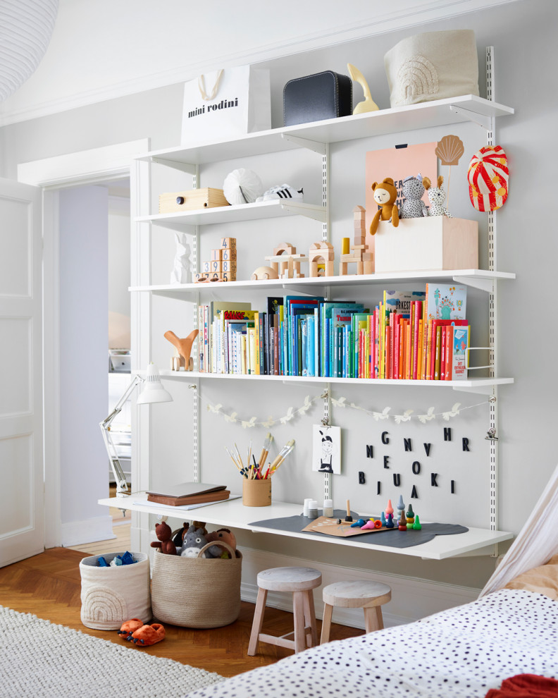Inspiration for a contemporary gender-neutral kids' bedroom for kids 4-10 years old in London with green walls, medium hardwood floors and beige floor.