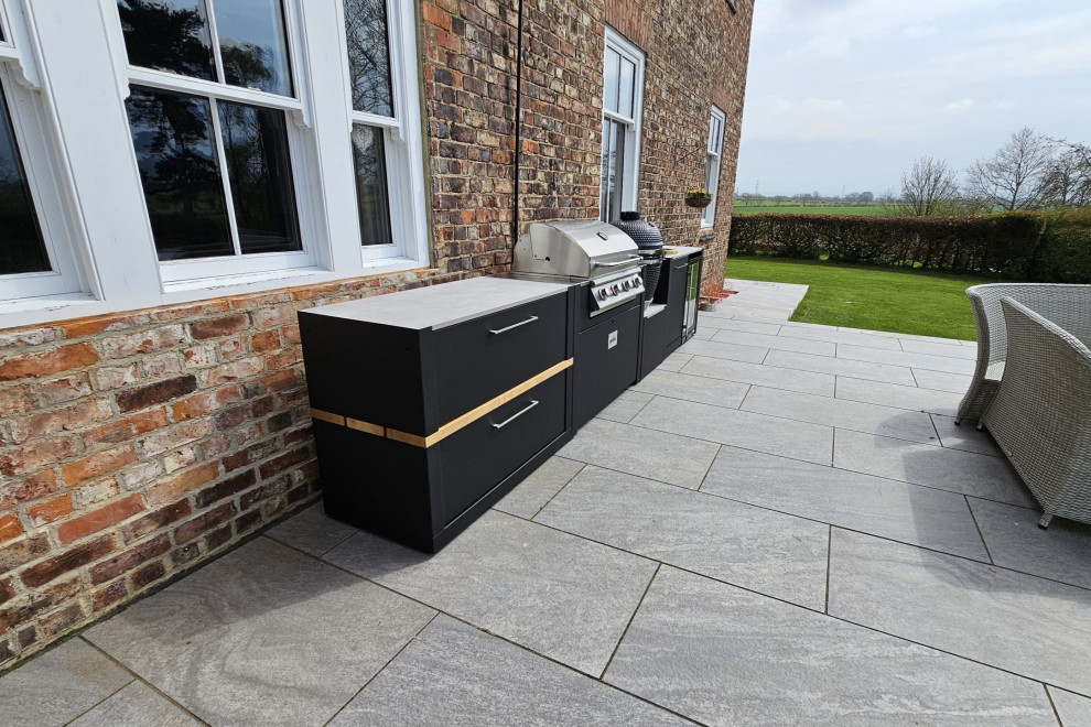 Inspiration for a medium sized contemporary back patio in Other with an outdoor kitchen, natural stone paving and no cover.