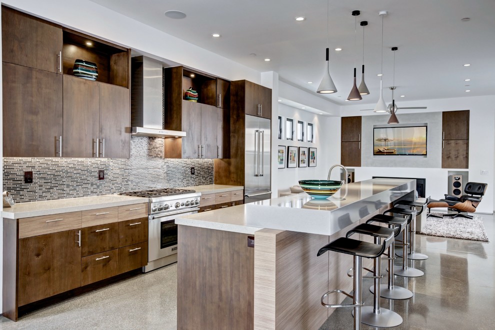 This is an example of a modern kitchen in Orange County with dark wood cabinets, grey splashback, stainless steel appliances and with island.