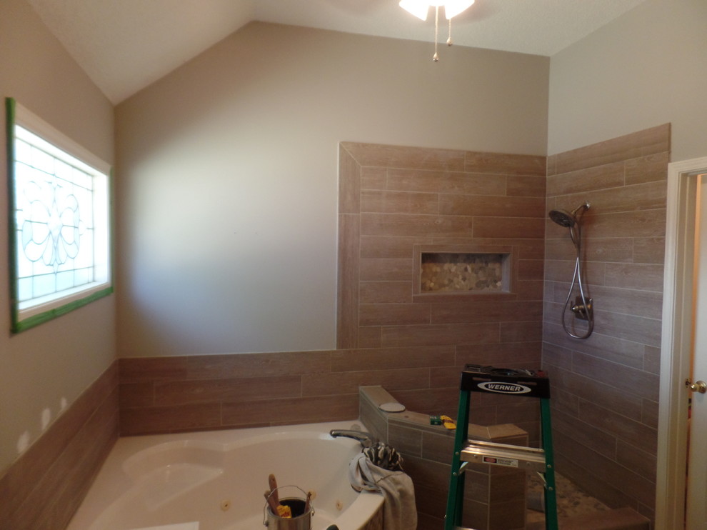 Inspiration for a mid-sized transitional master brown tile and porcelain tile corner shower remodel with beige walls and a hinged shower door