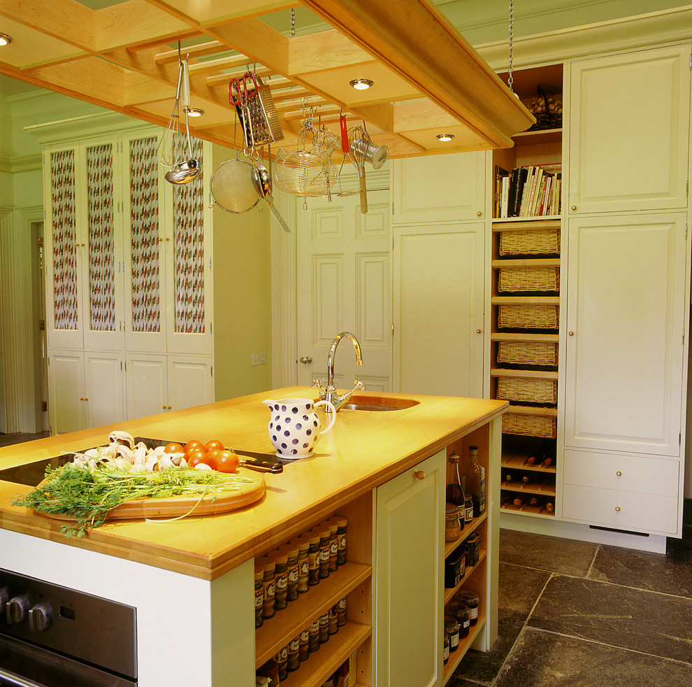 Design ideas for a large traditional grey and yellow galley kitchen/diner with raised-panel cabinets, wood worktops, a belfast sink, yellow cabinets, slate flooring, an island and grey floors.