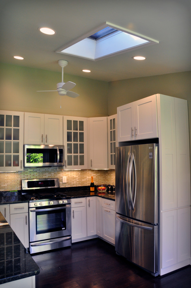 Eat-in kitchen - mid-sized transitional u-shaped dark wood floor eat-in kitchen idea in DC Metro with an undermount sink, shaker cabinets, white cabinets, granite countertops, yellow backsplash, glass tile backsplash, stainless steel appliances and a peninsula