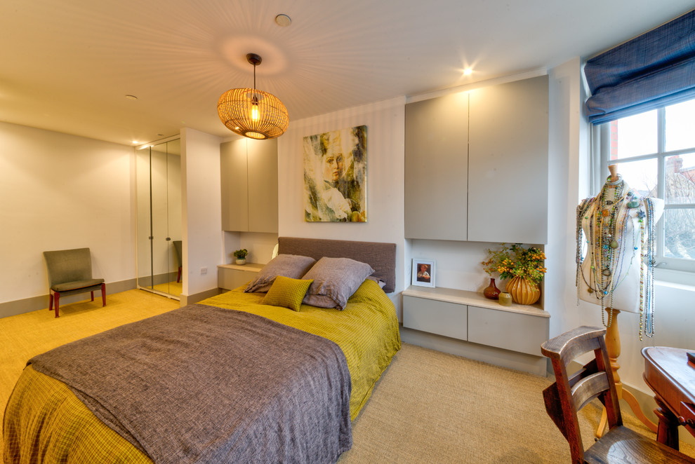 Photo of a mid-sized modern master bedroom in London with multi-coloured walls, carpet and beige floor.