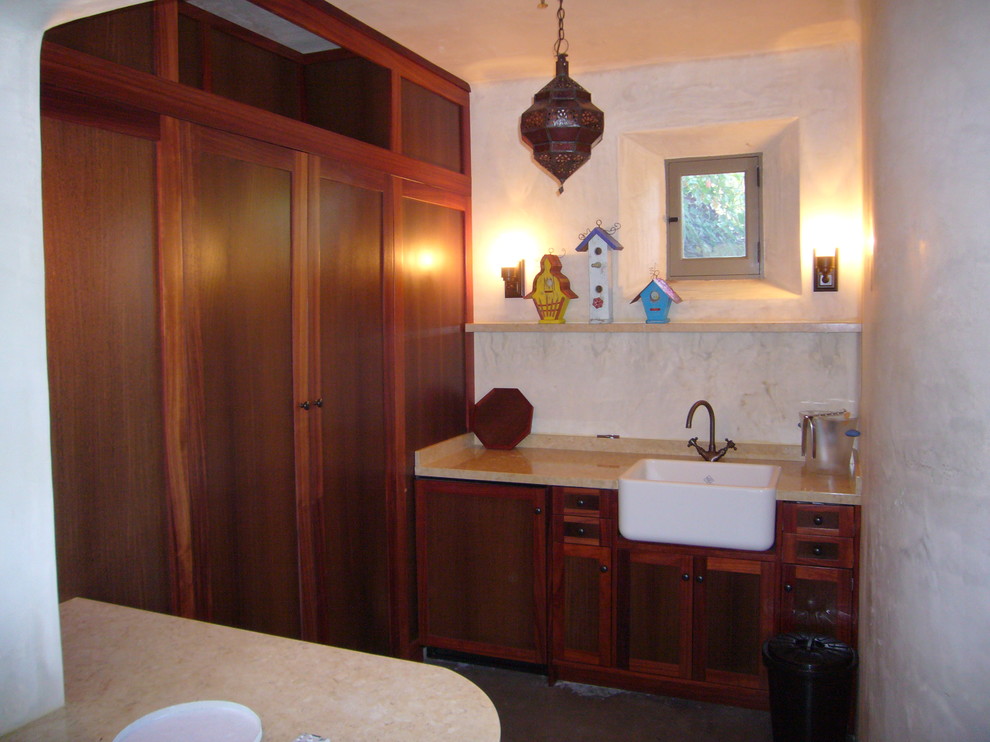 This is an example of a small mediterranean u-shaped separate kitchen in Other with a single-bowl sink, medium wood cabinets, granite benchtops, shaker cabinets, white splashback, concrete floors and no island.