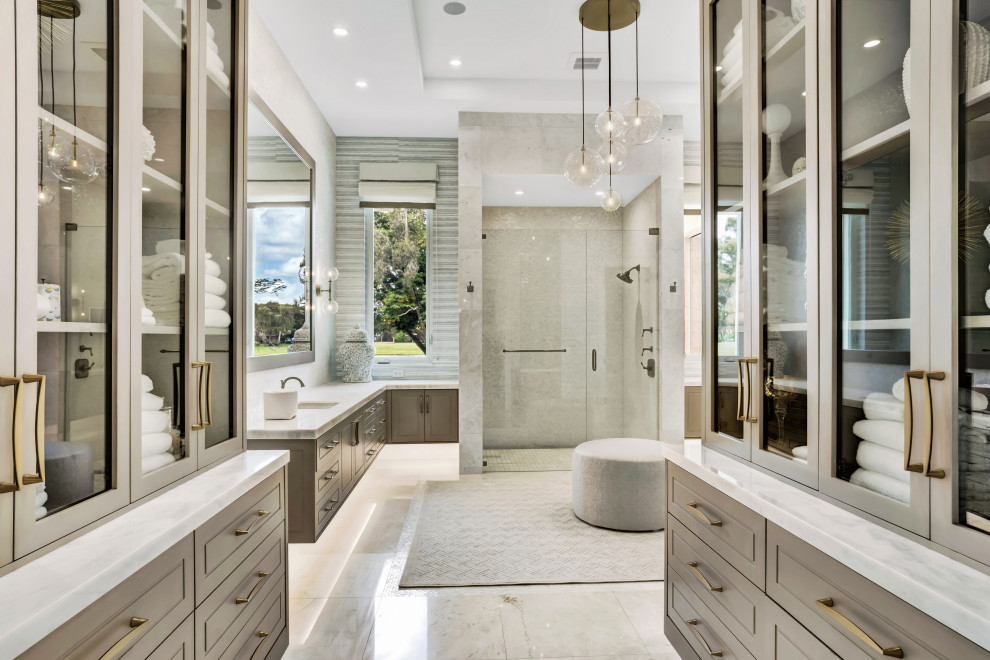 This is an example of a mid-sized contemporary 3/4 bathroom in Miami with furniture-like cabinets, grey cabinets, an alcove shower, a one-piece toilet, white tile, marble, white walls, marble floors, an undermount sink, marble benchtops, beige floor, a hinged shower door, white benchtops, a niche, a double vanity, a built-in vanity, recessed and wallpaper.