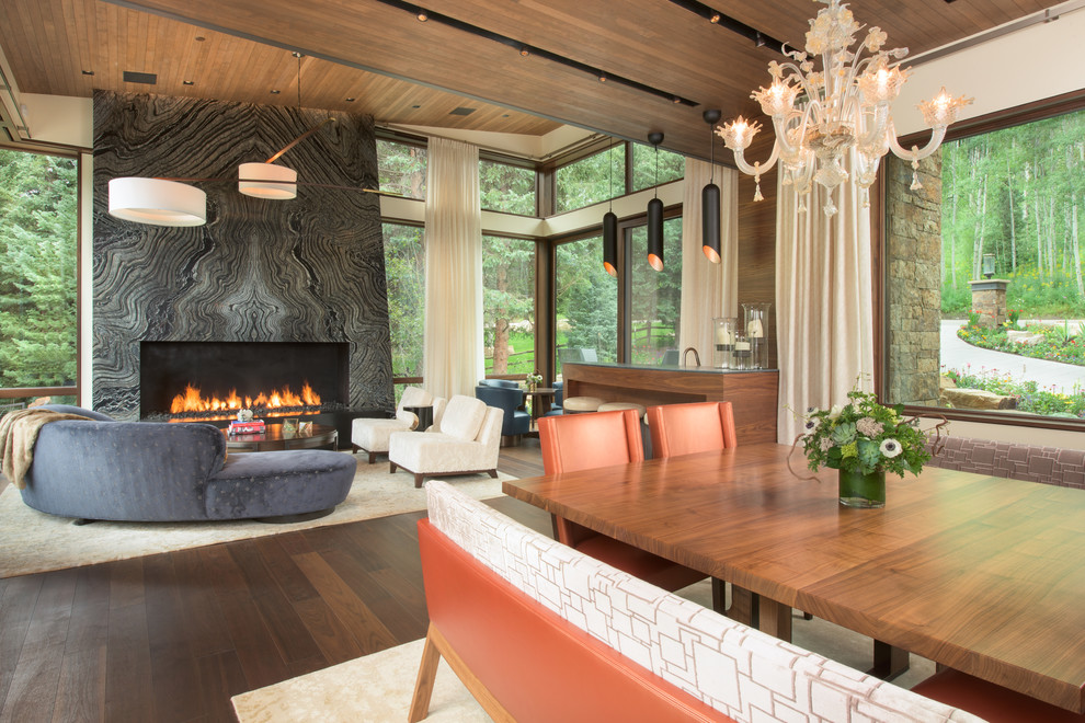 Photo of an expansive contemporary open plan dining in Denver with beige walls, medium hardwood floors and a stone fireplace surround.