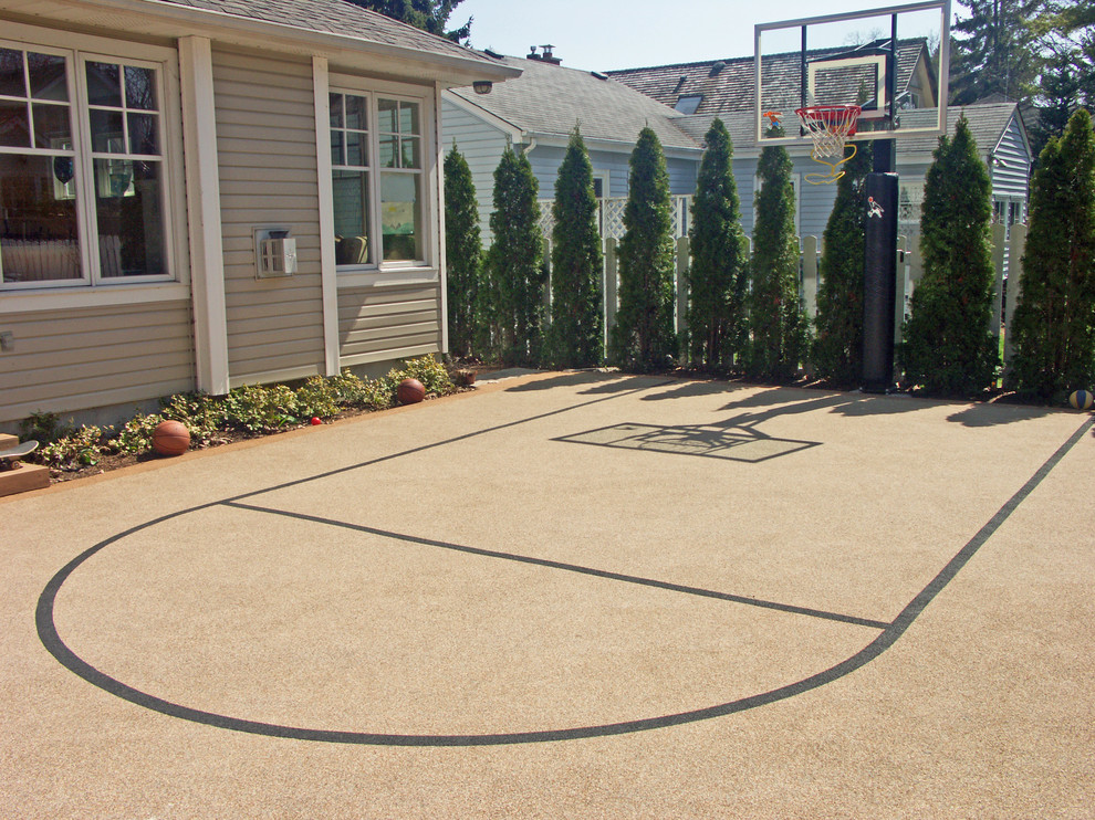 Photo of a large traditional backyard full sun outdoor sport court in Dallas with a retaining wall and natural stone pavers.