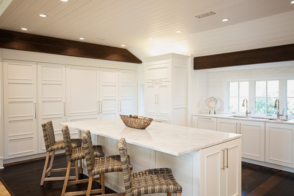 Large elegant u-shaped dark wood floor and brown floor eat-in kitchen photo in Miami with a drop-in sink, shaker cabinets, white cabinets, quartzite countertops, white backsplash, ceramic backsplash, paneled appliances, an island and white countertops