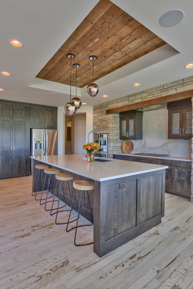 This is an example of a mid-sized country u-shaped eat-in kitchen in Omaha with a single-bowl sink, recessed-panel cabinets, dark wood cabinets, quartz benchtops, white splashback, ceramic splashback, stainless steel appliances, ceramic floors and with island.